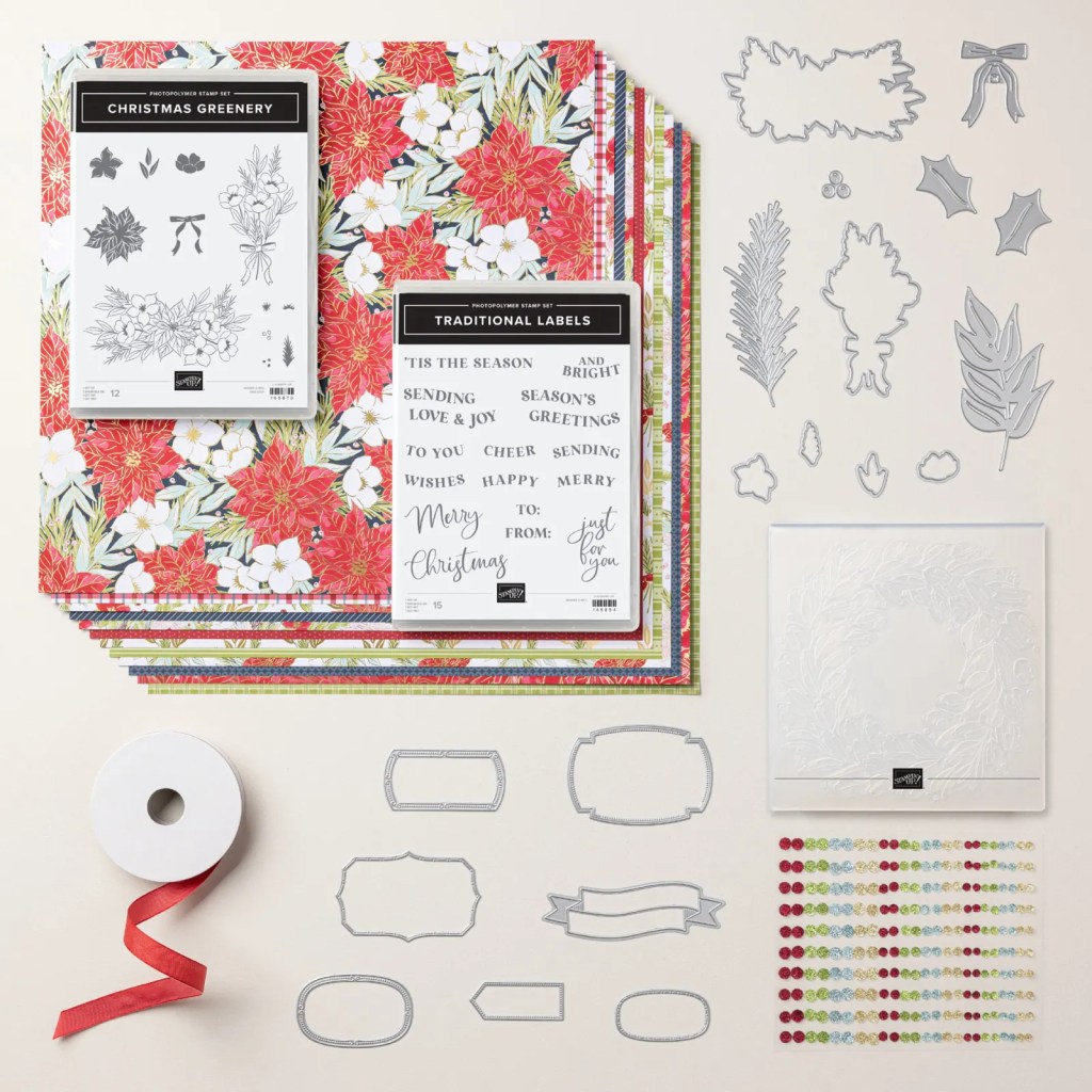 Display of Christmas-themed crafting materials including patterned paper, stamp sets, cutting dies, a roll of ribbon, and embellishments.