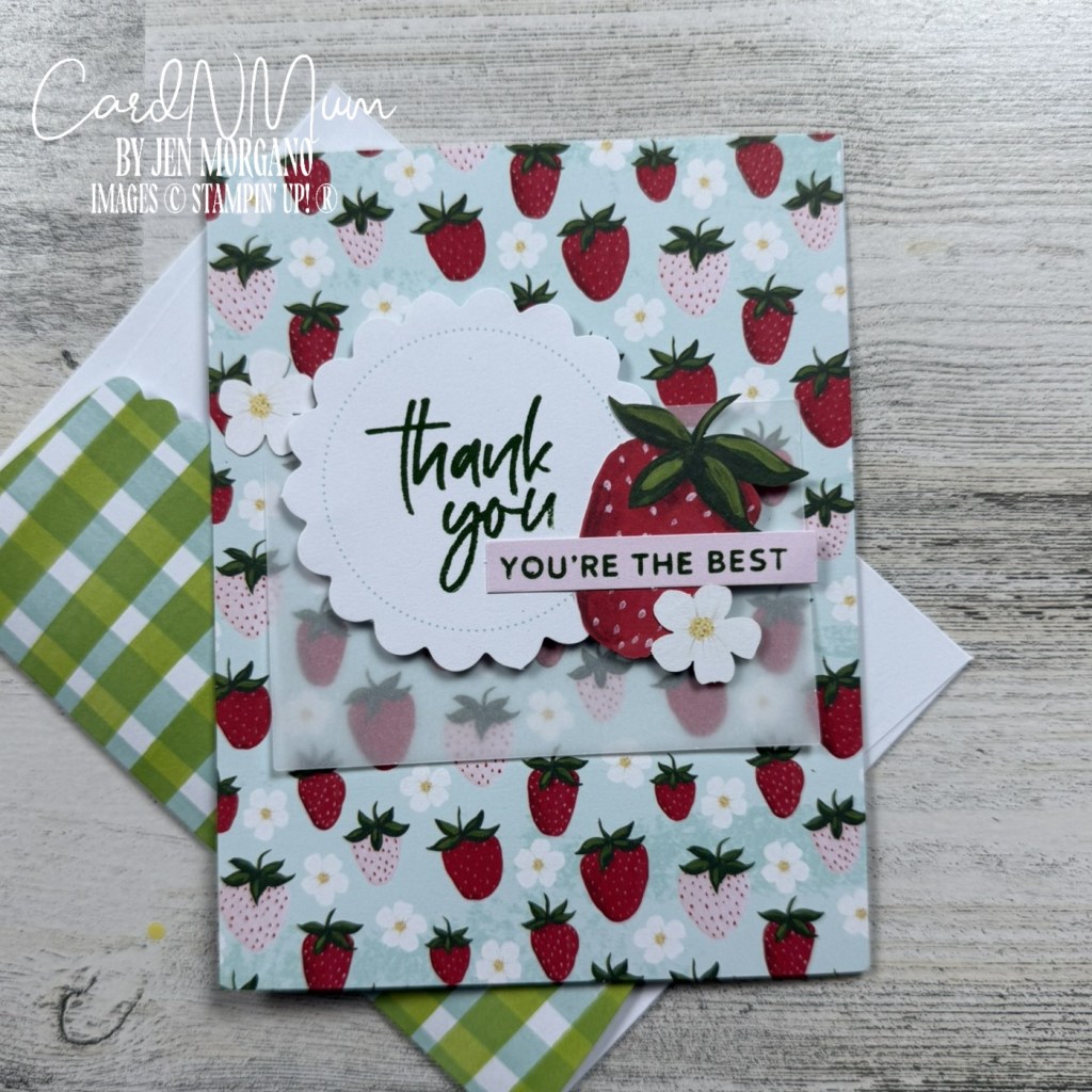 A thank you card featuring a strawberry design with the text 'thank you' and 'YOU'RE THE BEST' displayed prominently. The card has a light blue background with red strawberries and white flowers, accompanied by a green and white checkered envelope.