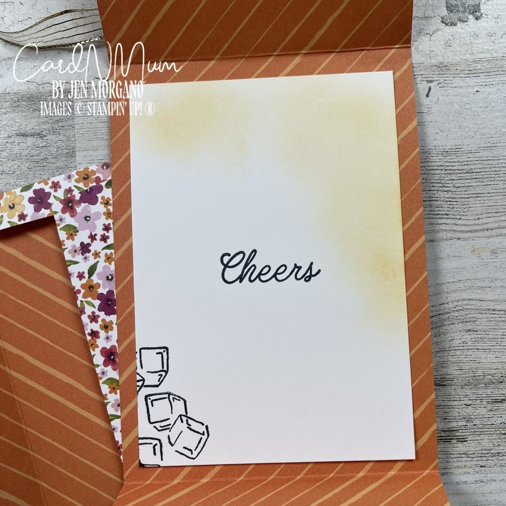 Inside of a handmade card featuring a light orange background with a 'Cheers' greeting in a stylish font and images of ice cubes in the bottom corner.
