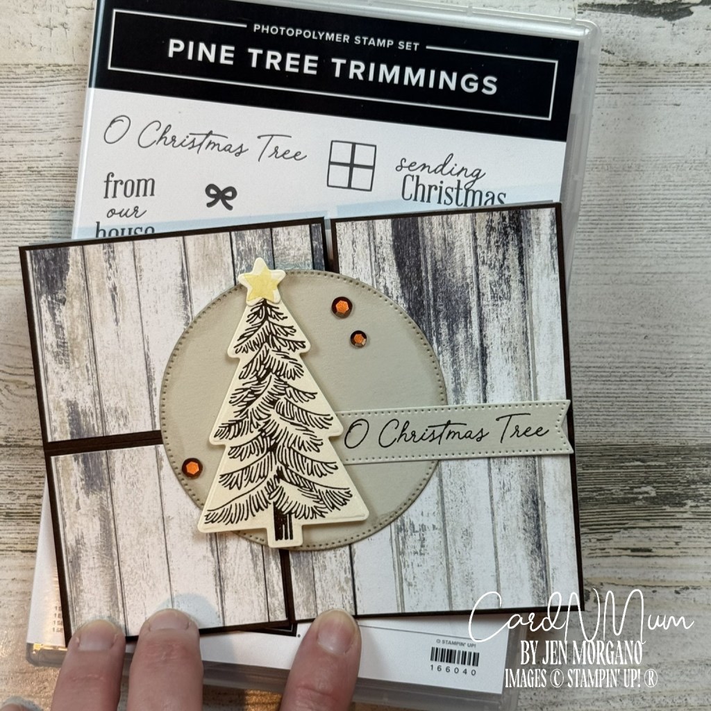 A handmade card featuring a Puzzle Piece fold with a rustic wood background, adorned with a stamped Christmas tree, a star, and orange embellishments, along with the text 'O Christmas Tree.'