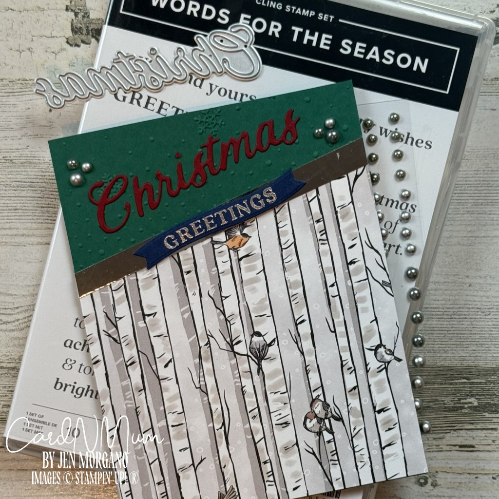A handmade Christmas card featuring a green top panel with the words 'Christmas' in red and 'Greetings' in gold. The card design includes birch tree patterns and decorative pearls, with a stamp set and dies from the 'Words for the Season' bundle in the background.