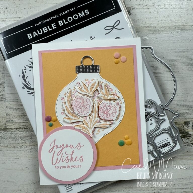 A greeting card featuring a festive ornament design with floral elements and the text 'Joyous Wishes to you & yours.' The card is displayed with a stamp set labeled 'Bauble Blooms' in the background.