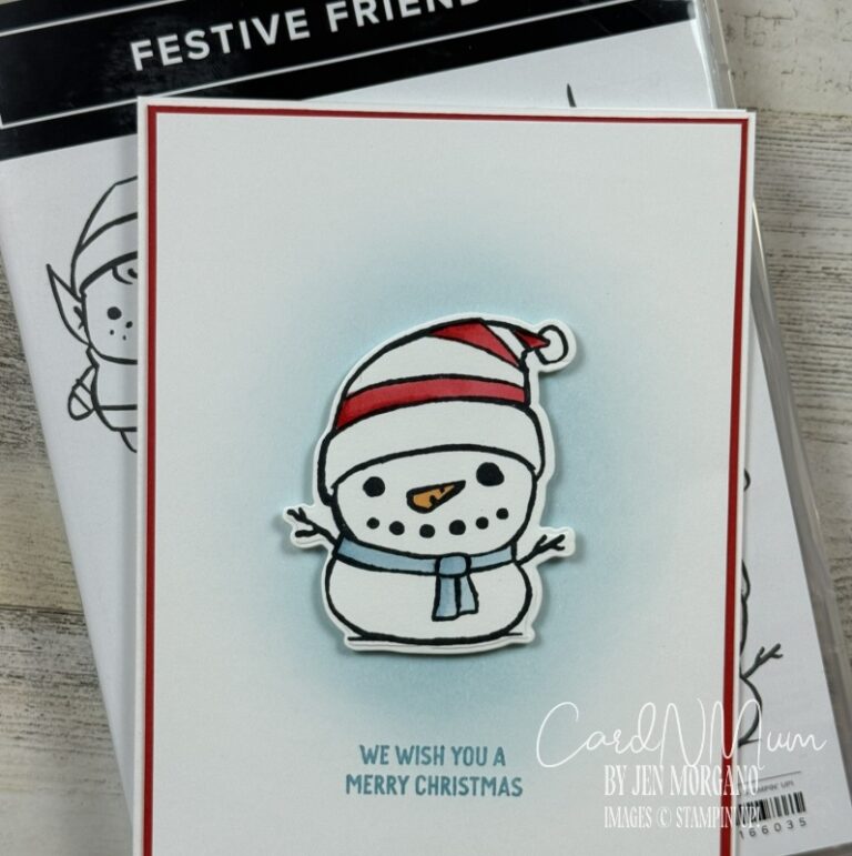 A cheerful snowman wearing a red and white striped hat and a blue scarf, with the text 'We wish you a Merry Christmas' below it. The snowman is placed on a white card with a light blue background.