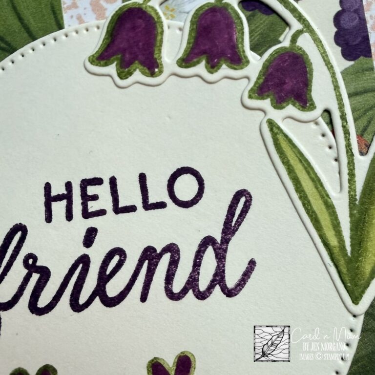 Close up of circular die cut with hello friend greeting and purple floral accents