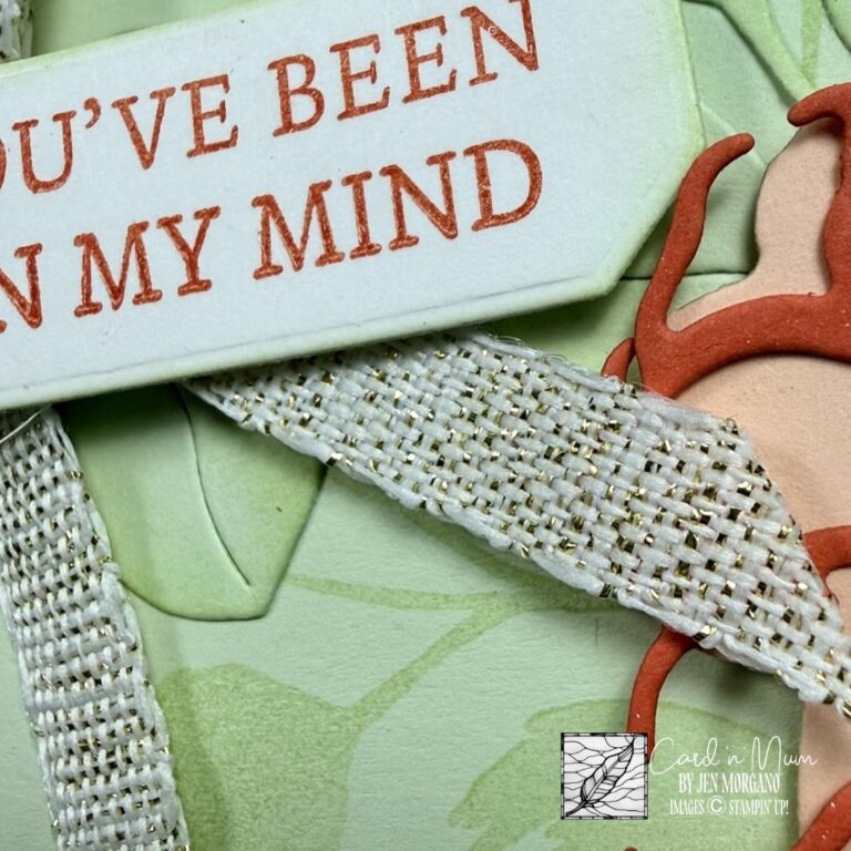 Close-up of a handmade stamped card with the sentiment “You’ve been on my mind,” featuring soft green cardstock, textured ribbon, and a partial flower embellishment